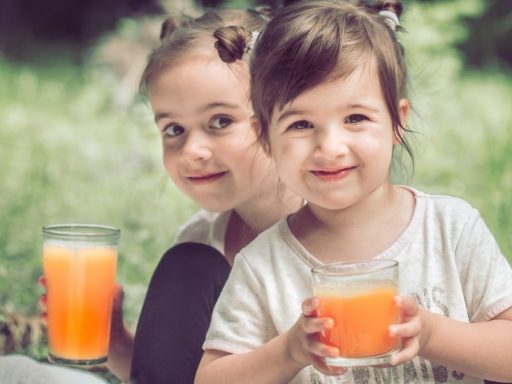 two-little-sisters-drinking-juice.jpg